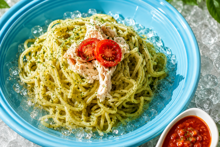 冷製バジルパスタ。氷を敷いた青い皿に盛り、味変用のトマトガーリックソースを添えた一皿