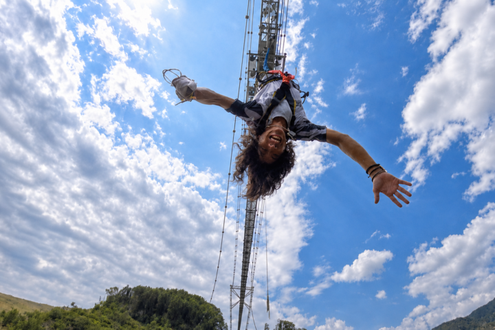 GODA BRIDGEから飛び降りるバンジージャンプの瞬間。青空を背景にした空中の姿